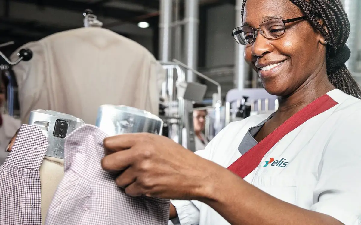 Mitarbeiterin in einer professionellen Textilreinigung prüft Textilien nach der Reinigung